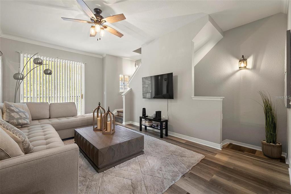 A living room features a sectional sofa, a wooden coffee table, and a wall-mounted television — 126 BEACH HAVEN LANE UNIT 126, TAMPA, FL