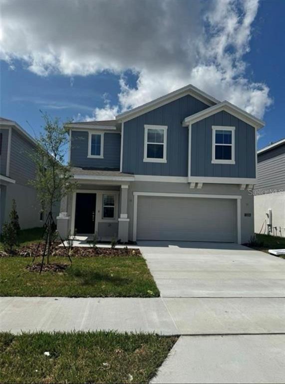 A two-story house with blue siding, a two-car garage, and a small front yard — 1334 DIEGO TERRACE, WINTER HAVEN, FL