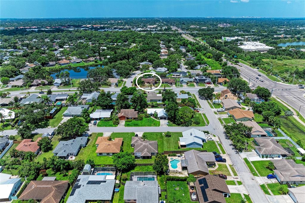 An aerial view shows a residential neighborhood with a circled house near a main road — 6540 MAUNA LOA BOULEVARD, SARASOTA, FL