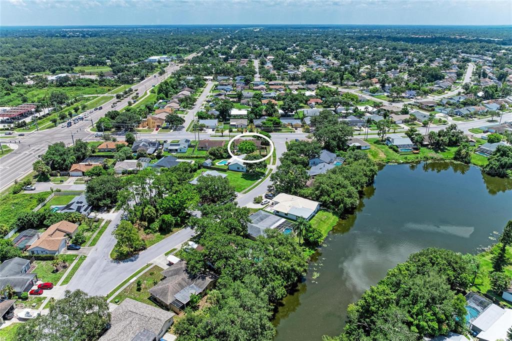 An aerial view shows a residential neighborhood with a circled house near a lake — 6540 MAUNA LOA BOULEVARD, SARASOTA, FL
