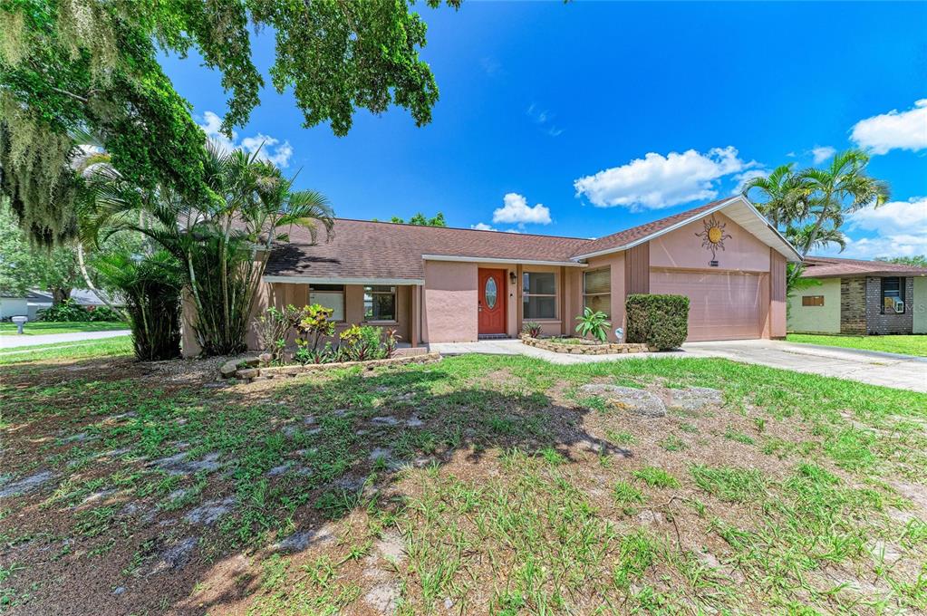 A single-story house with a tan exterior, a red front door, and a two-car garage — 6540 MAUNA LOA BOULEVARD, SARASOTA, FL