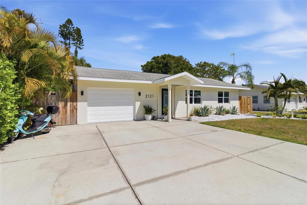 A single-story house with a white garage, concrete driveway, and a light-colored exterior — 2121 PALM TERRACE, SARASOTA, FL