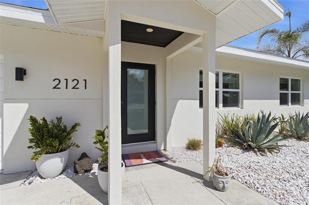 The exterior of a white house features a black front door and a covered entryway — 2121 PALM TERRACE, SARASOTA, FL