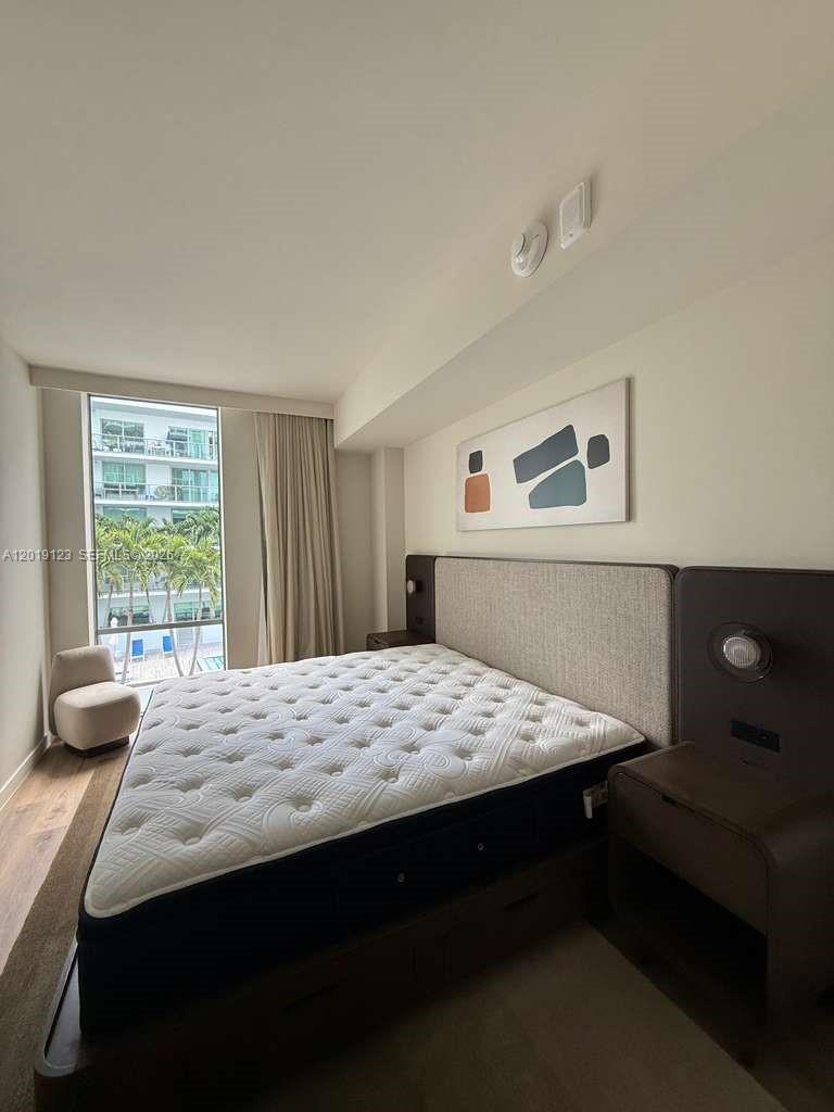 A bedroom features a bed with a tufted mattress, a headboard, and a large window — 1611 SW 2nd ave # 510, Miami FL 33129, MIAMI, FL