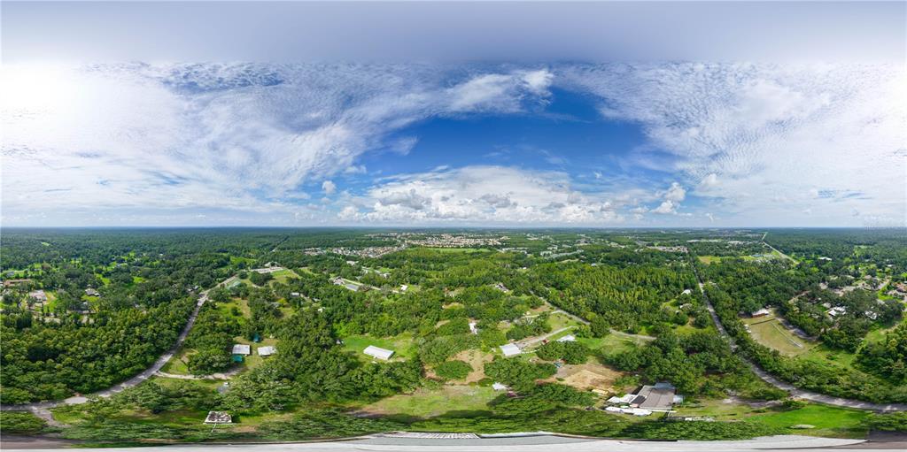 An aerial 360-degree panoramic view shows a rural landscape with scattered houses, trees, and roads — 15370 APACHE DRIVE, THONOTOSASSA, FL