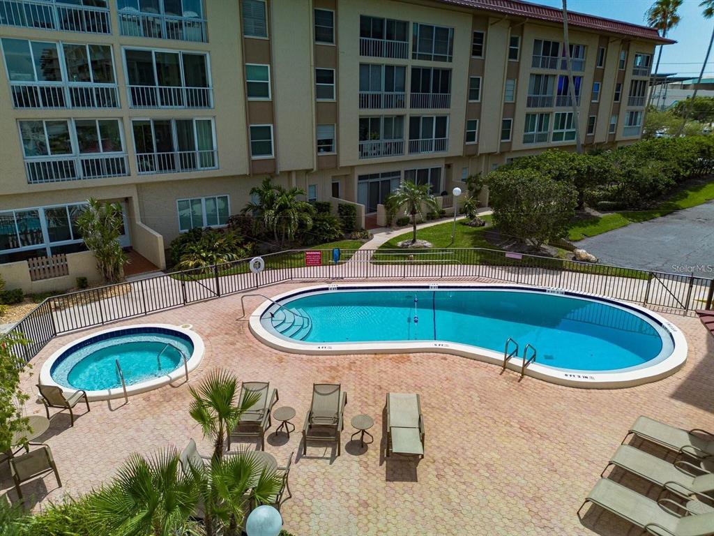 An elevated view of a swimming pool and hot tub surrounded by a paved patio — 105 ISLAND WAY UNIT 138, CLEARWATER BEACH, FL
