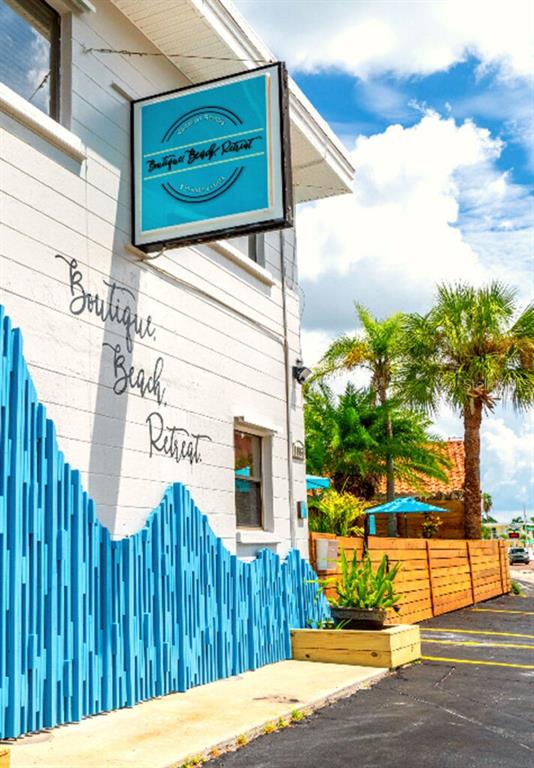 A two-story boutique beach retreat hotel building sits along a road at sunset — 11965 GULF BOULEVARD, ST PETERSBURG, FL