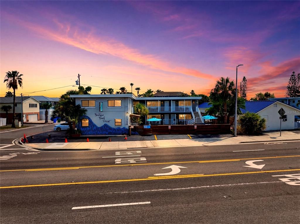 A two-story motel building with a swimming pool and patio area in the courtyard — 11965 GULF BOULEVARD, ST PETERSBURG, FL