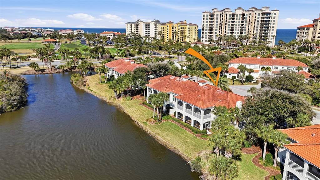 A two-story white building with arched balconies and a lawn under a blue sky — 16 VISCAYA DRIVE UNIT 204, PALM COAST, FL
