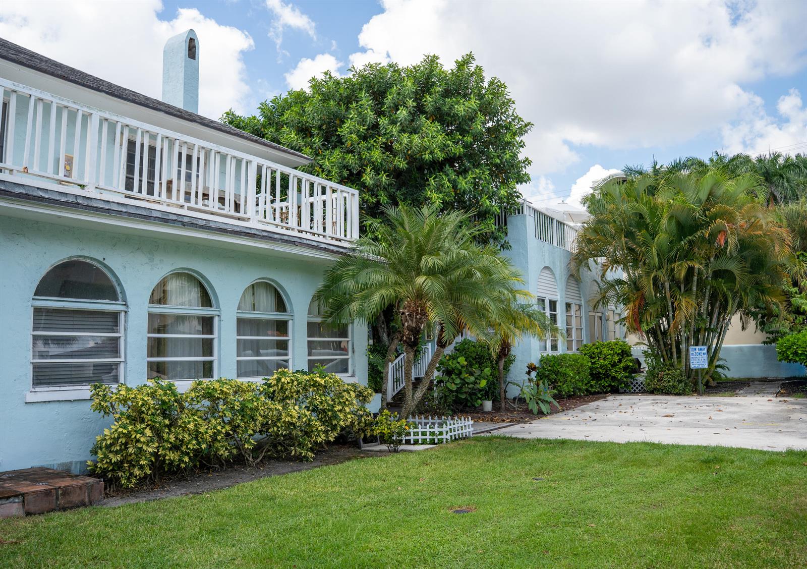 A light blue, two-story building with arched windows, a white balcony, and surrounding palm trees — 264 Seminole Avenue, Palm Beach FL 33480, PALM BEACH, FL