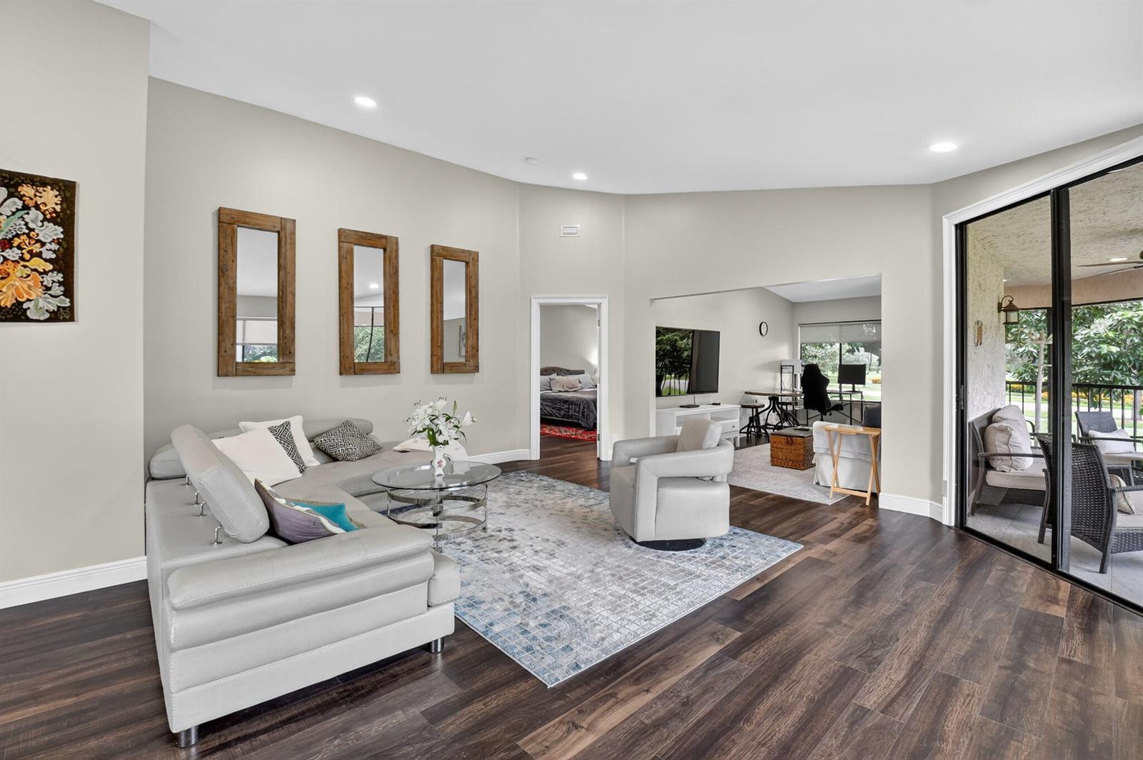 A living room features a grey sectional sofa, a patterned rug, and sliding glass doors — 15307 Strathearn Drive # 11204, Delray Beach FL 33446, DELRAY BEACH, FL