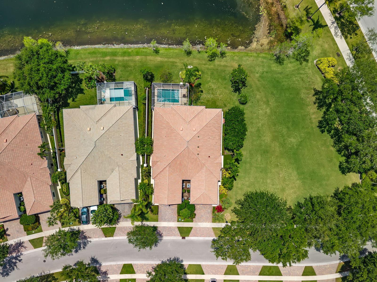 An aerial view shows two houses with pools and tile roofs next to a large lawn — 3214 Verdmont Lane, Wellington FL 33414, WELLINGTON, FL