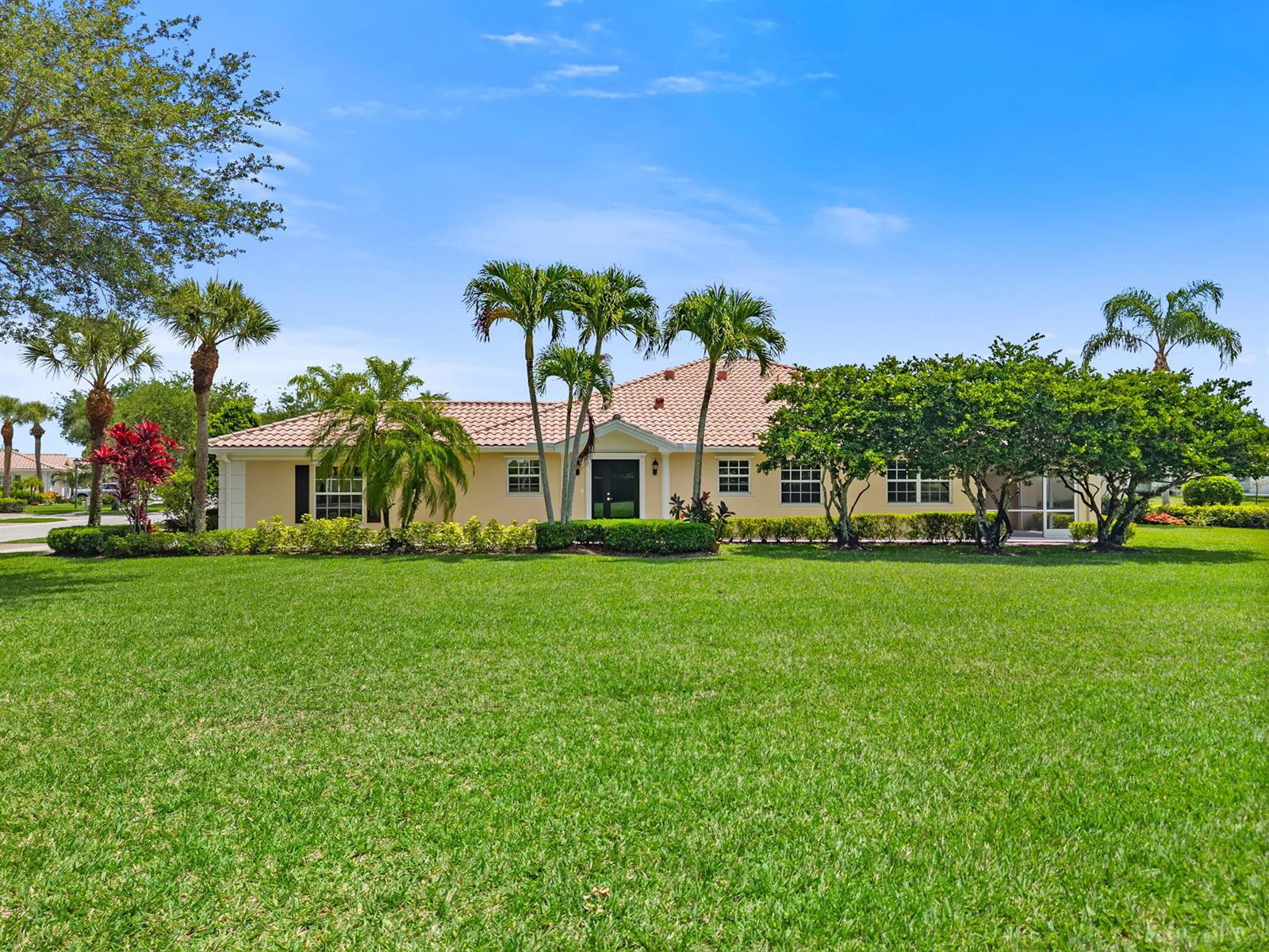 A single-story house with a tile roof and palm trees sits behind a large lawn — 3214 Verdmont Lane, Wellington FL 33414, WELLINGTON, FL