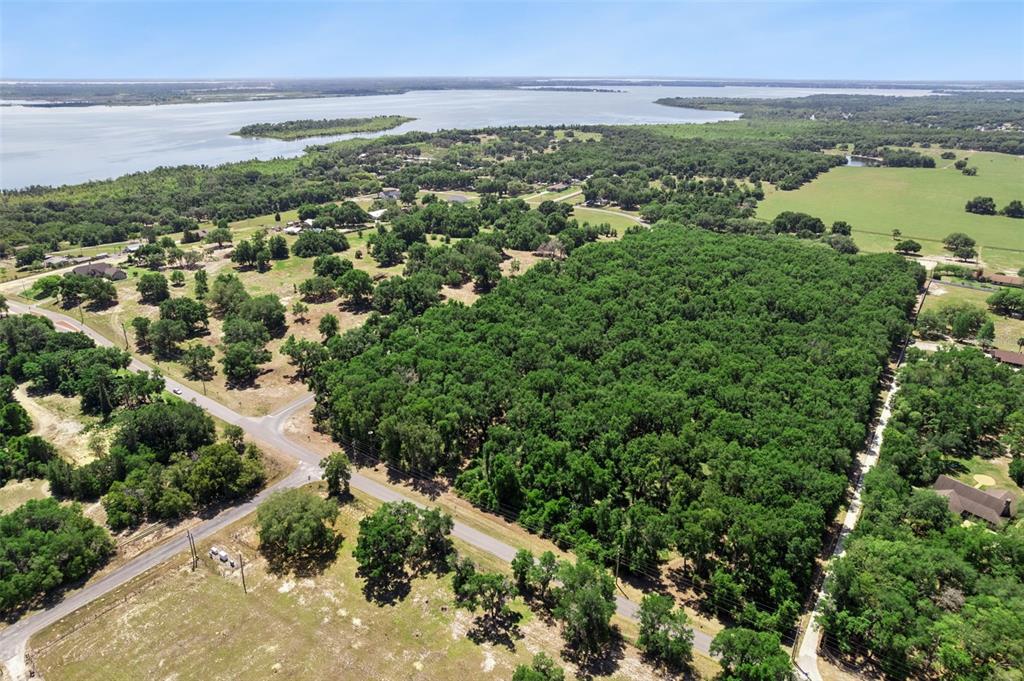 An aerial view shows a large wooded lot bordered by roads near a lake — 0000 BERTSVILLE & GRIFFIN VIEW ROAD, LADY LAKE, FL