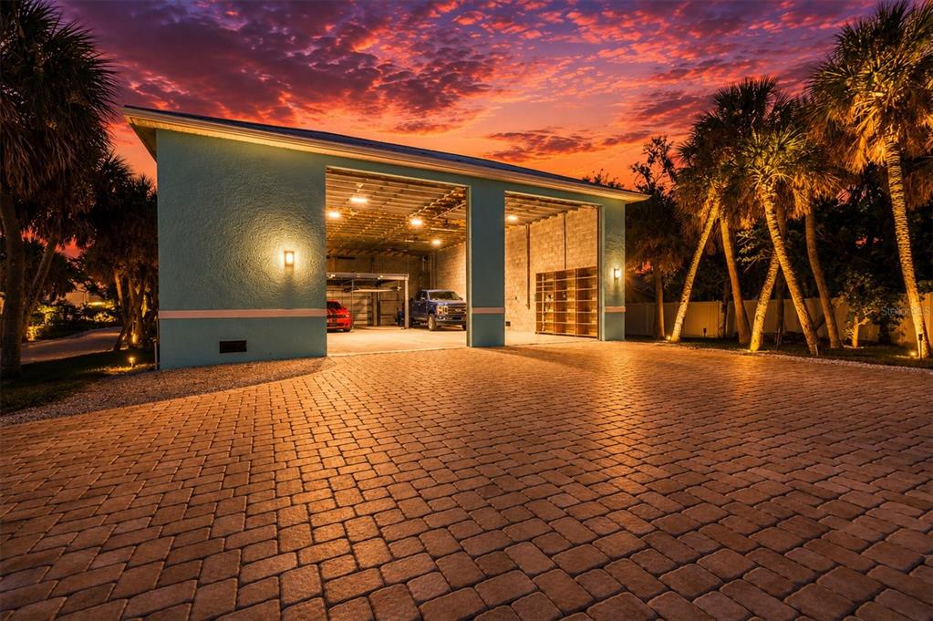 A detached two-car garage with a paved driveway under a vibrant sunset sky — 6065 MANASOTA KEY ROAD, ENGLEWOOD, FL
