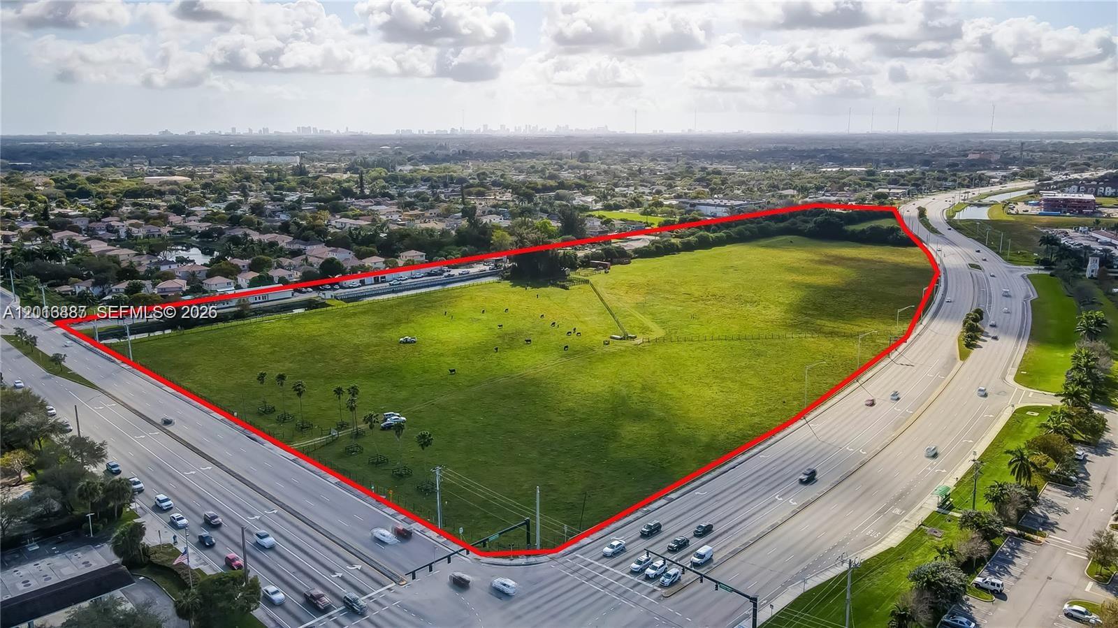 An aerial view shows a large, vacant grassy lot bordered by two busy multi-lane roads — 8020 Stirling Rd, Davie FL 33024, DAVIE, FL