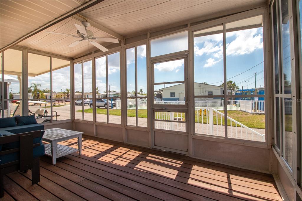 A screened-in porch with wood flooring, a ceiling fan, and views of a neighborhood street — 2812 14TH STREET W, PALMETTO, FL