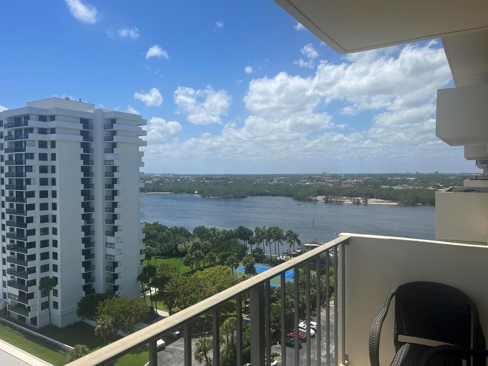 A high-angle view from a balcony overlooking a river, a tennis court, and nearby buildings — 2121 N Ocean Boulevard # 1405e, Boca Raton FL 33431, BOCA RATON, FL