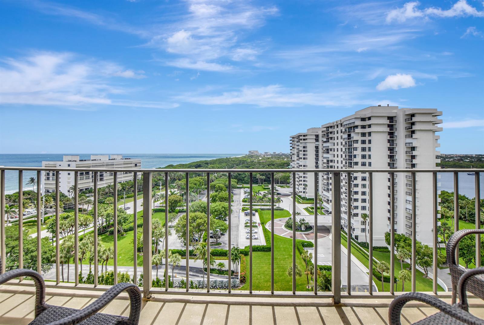 A balcony view overlooking a parking lot, green landscaping, and high-rise buildings near the ocean — 2121 N Ocean Boulevard # 1405e, Boca Raton FL 33431, BOCA RATON, FL