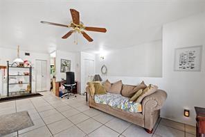 A living room features a beige sofa, tile flooring, a ceiling fan, and a desk area — 504 Gardens Drive # 203, Pompano Beach FL 33069, POMPANO BEACH, FL