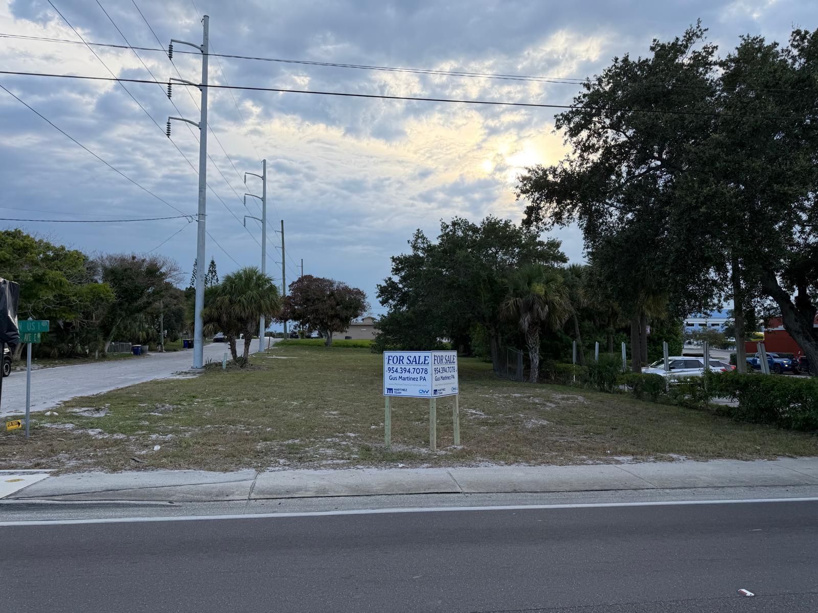 A vacant lot with a for sale sign sits beside a road and power lines — 408 Avenue E, Fort Pierce FL 34950, FORT PIERCE, FL