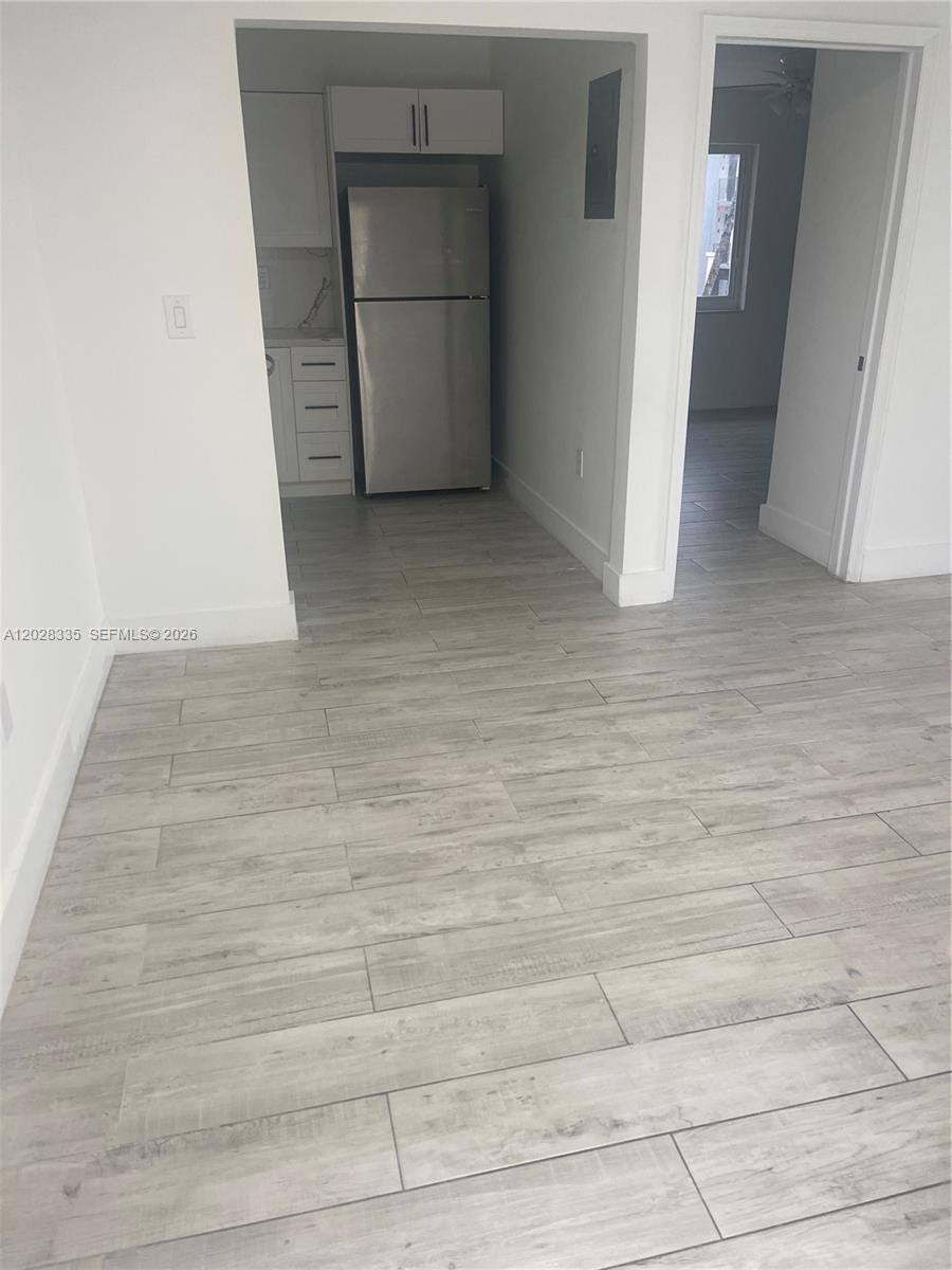 A kitchen area with a stainless steel refrigerator and light wood-look tile flooring — 2008 SW 3rd St # 4, Miami FL 33135, MIAMI, FL