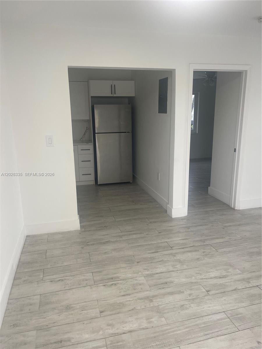 A kitchen with stainless steel appliances and white cabinets is visible from a living area — 2008 SW 3rd St # 4, Miami FL 33135, MIAMI, FL