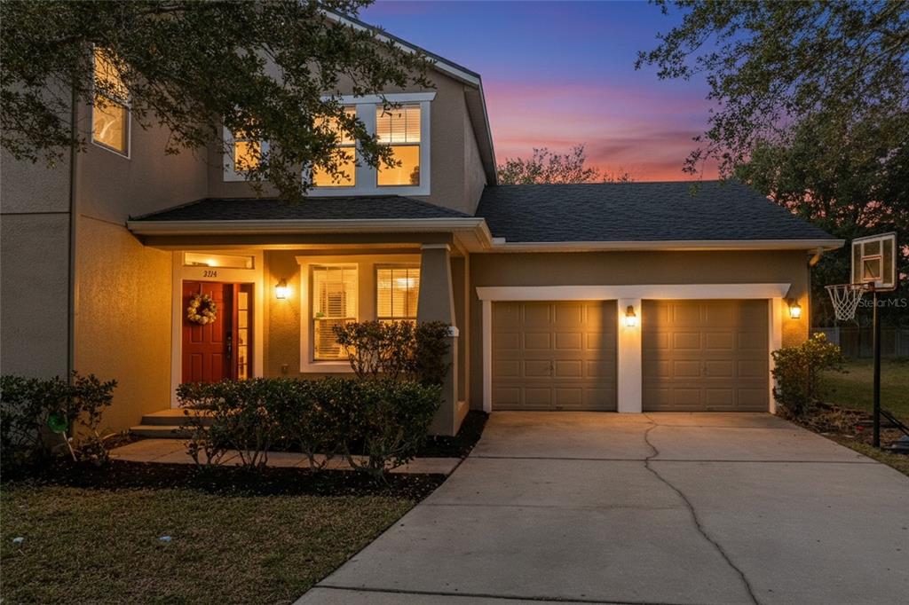 A two-story house with a red front door, two-car garage, and a concrete driveway — 3214 HOPEWELL DRIVE, KISSIMMEE, FL