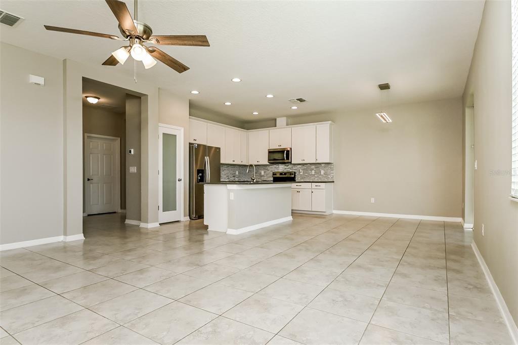 A spacious kitchen with white cabinets, stainless steel appliances, and tile flooring — 10313 BERRYESSA AVENUE, RIVERVIEW, FL