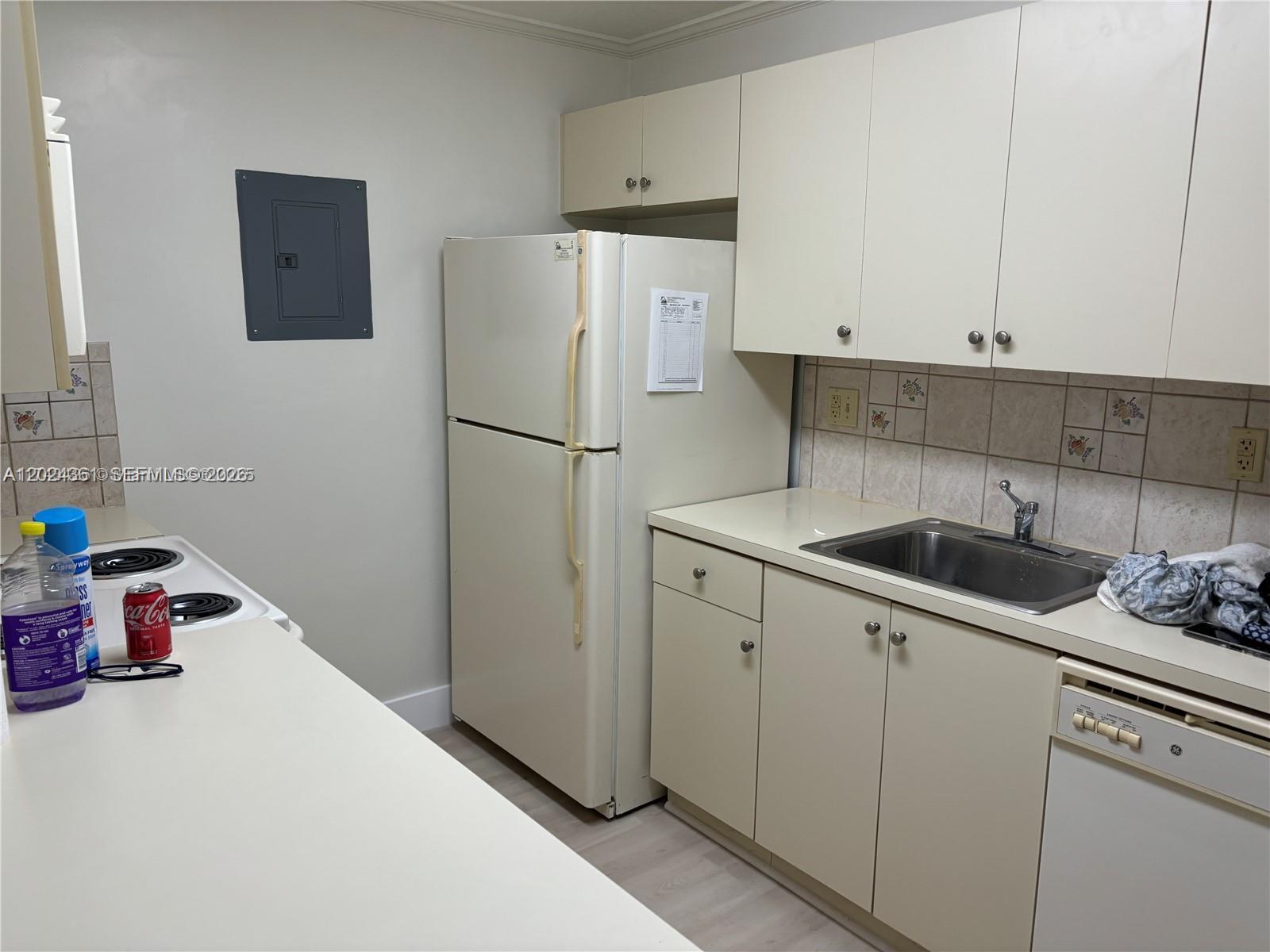 A kitchen features off-white cabinets, a refrigerator, a stainless steel sink, and an electric stove — 10744 N Kendall # 18, Miami FL 33176, MIAMI, FL