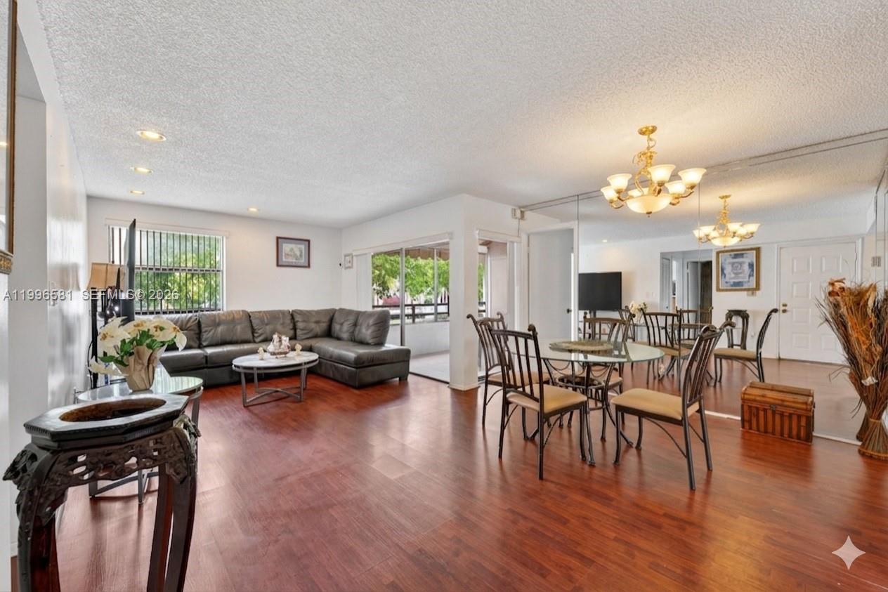 A living and dining area with wood floors, a sectional sofa, and a glass table — 20015 NE 3rd Ct # 6, Miami FL 33179, MIAMI, FL