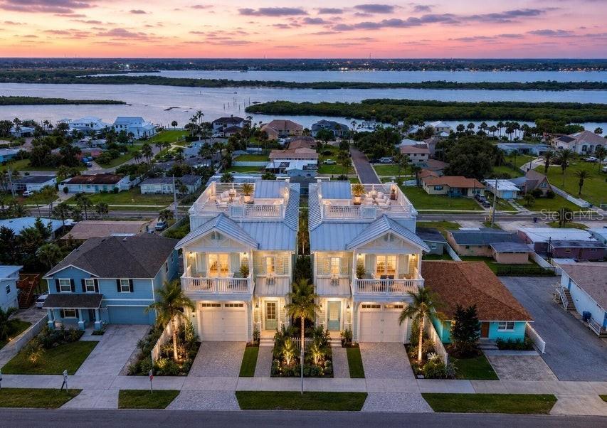 An aerial view shows two identical coastal-style houses with rooftop decks and attached garages — 3826 S ATLANTIC AVENUE, DAYTONA BEACH SHORES, FL