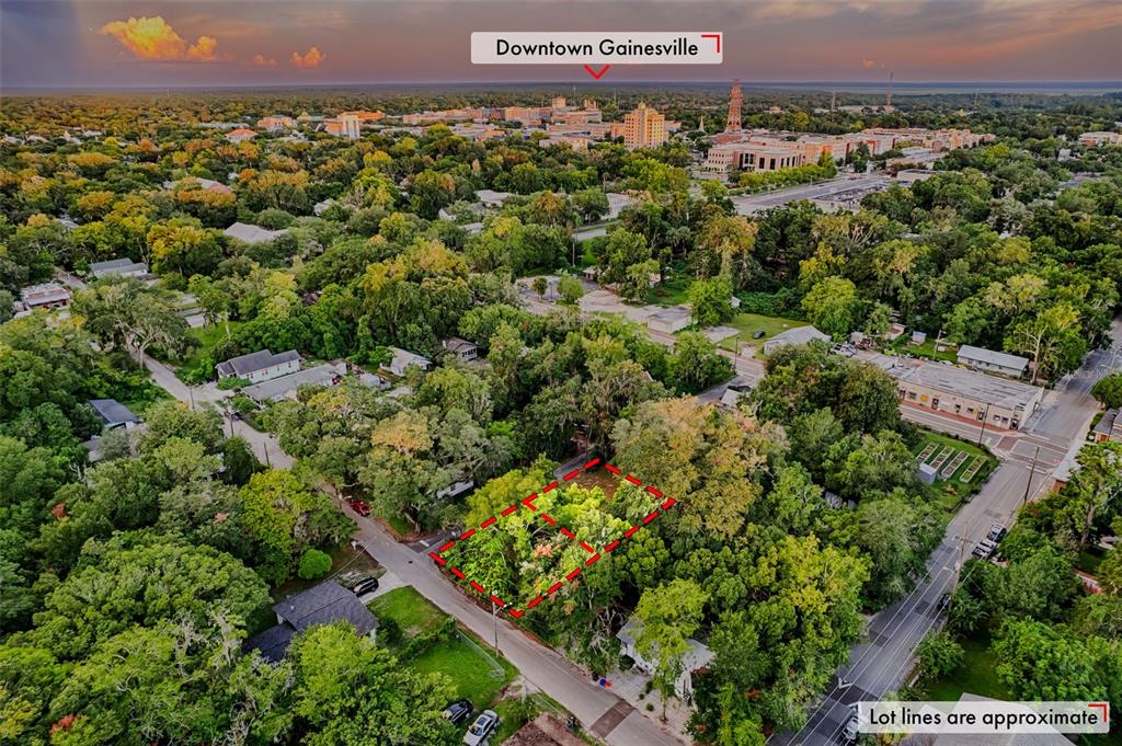 An aerial view shows a vacant, tree-covered lot outlined in red within a residential neighborhood — 534 & 580 NW 7TH TERRACE, GAINESVILLE, FL