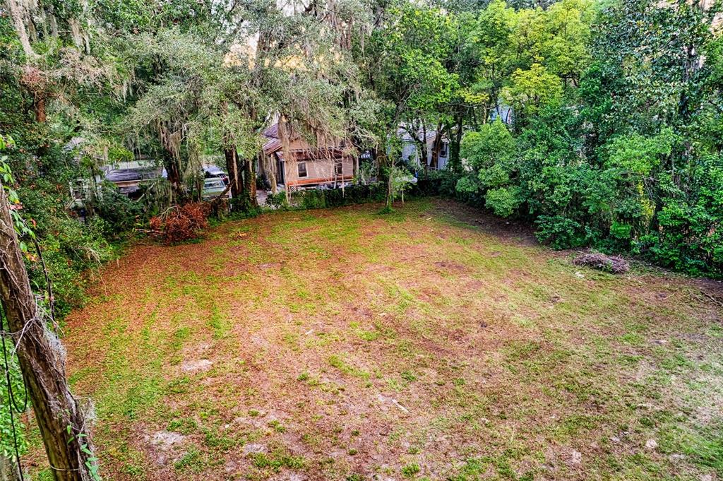 An elevated view of a large, cleared grassy lot surrounded by mature trees and houses — 534 & 580 NW 7TH TERRACE, GAINESVILLE, FL