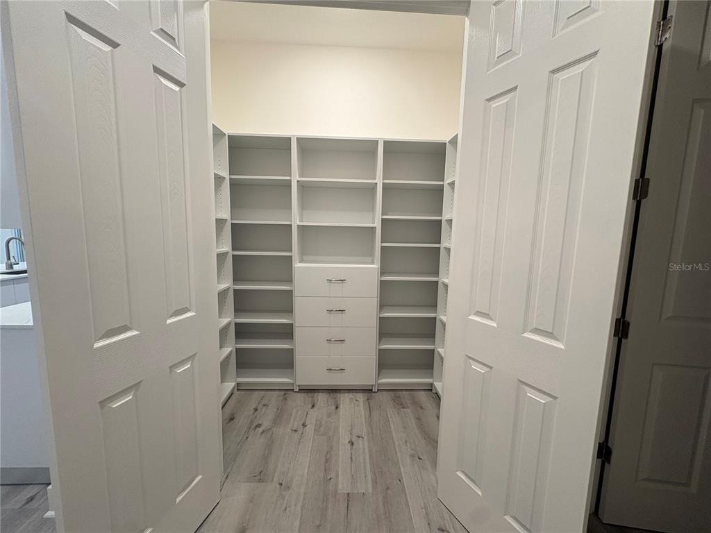 A walk-in closet features white shelving, a four-drawer dresser, and light wood-look flooring — 14681 KEYSTONE BOULEVARD, PORT CHARLOTTE, FL