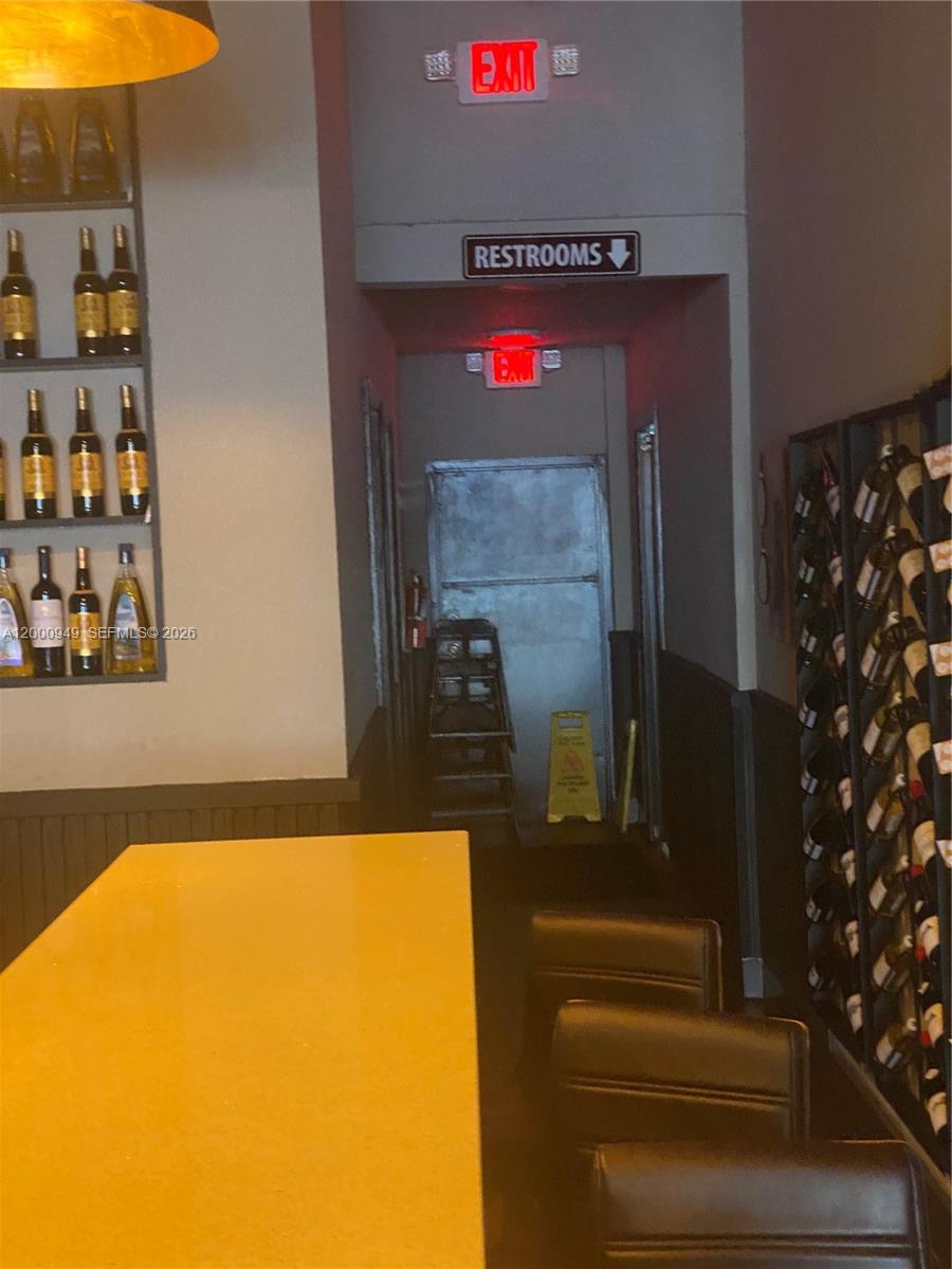 A bar area features wine racks, a counter, and a hallway leading to restrooms — 9511 S DIXIE HWY, Pinecrest FL 33156, PINECREST, FL