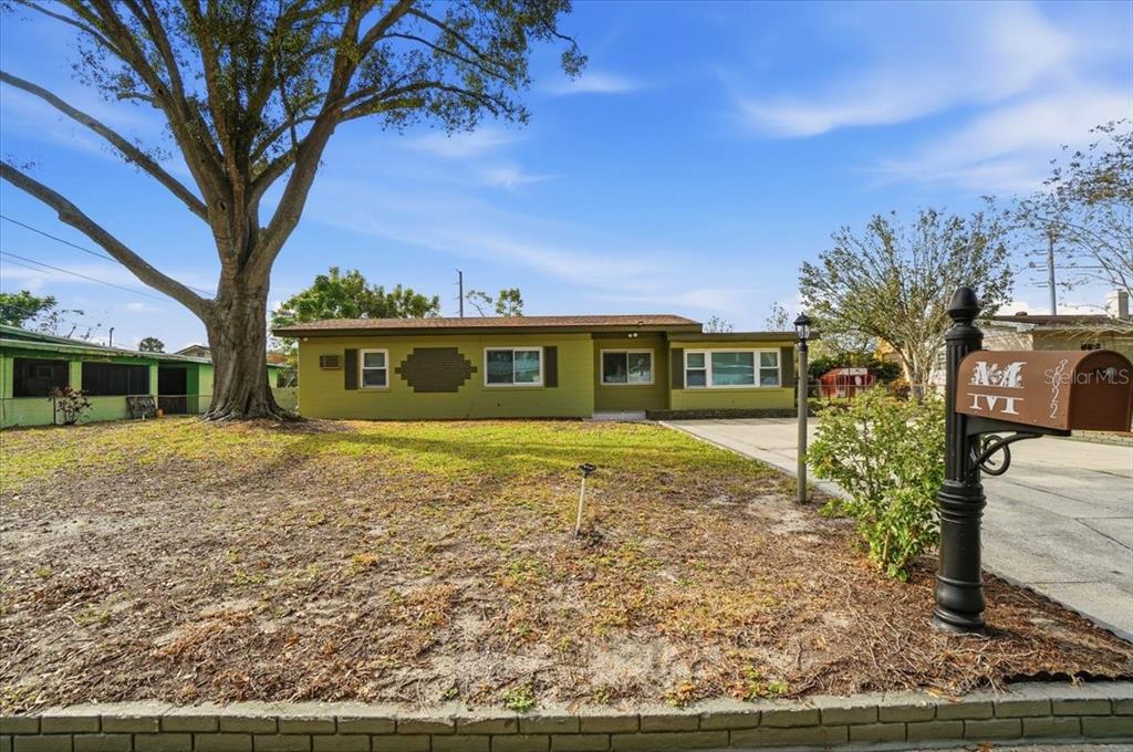 A single-story house with green siding and a large tree in the front yard — 3022 HICKORY STREET NW, WINTER HAVEN, FL