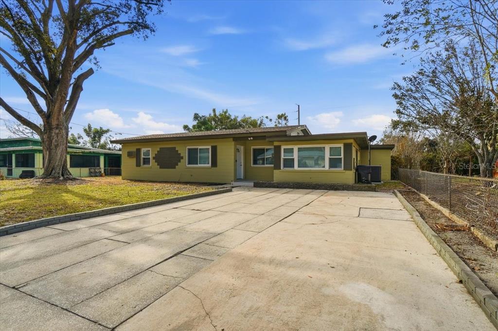 A single-story house with olive green siding and a large concrete driveway — 3022 HICKORY STREET NW, WINTER HAVEN, FL