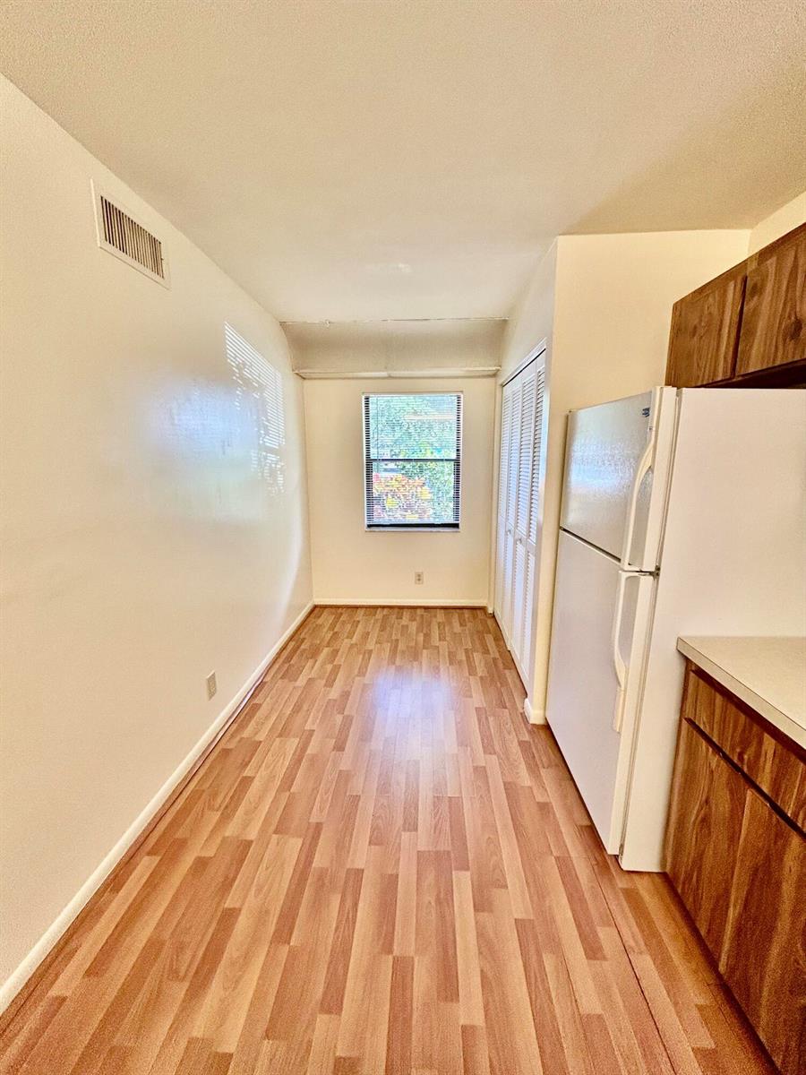A grassy lawn with two large trees overlooks a narrow canal and distant palm trees — 2900 SW 22nd Circle # 221d, Delray Beach FL 33445, DELRAY BEACH, FL