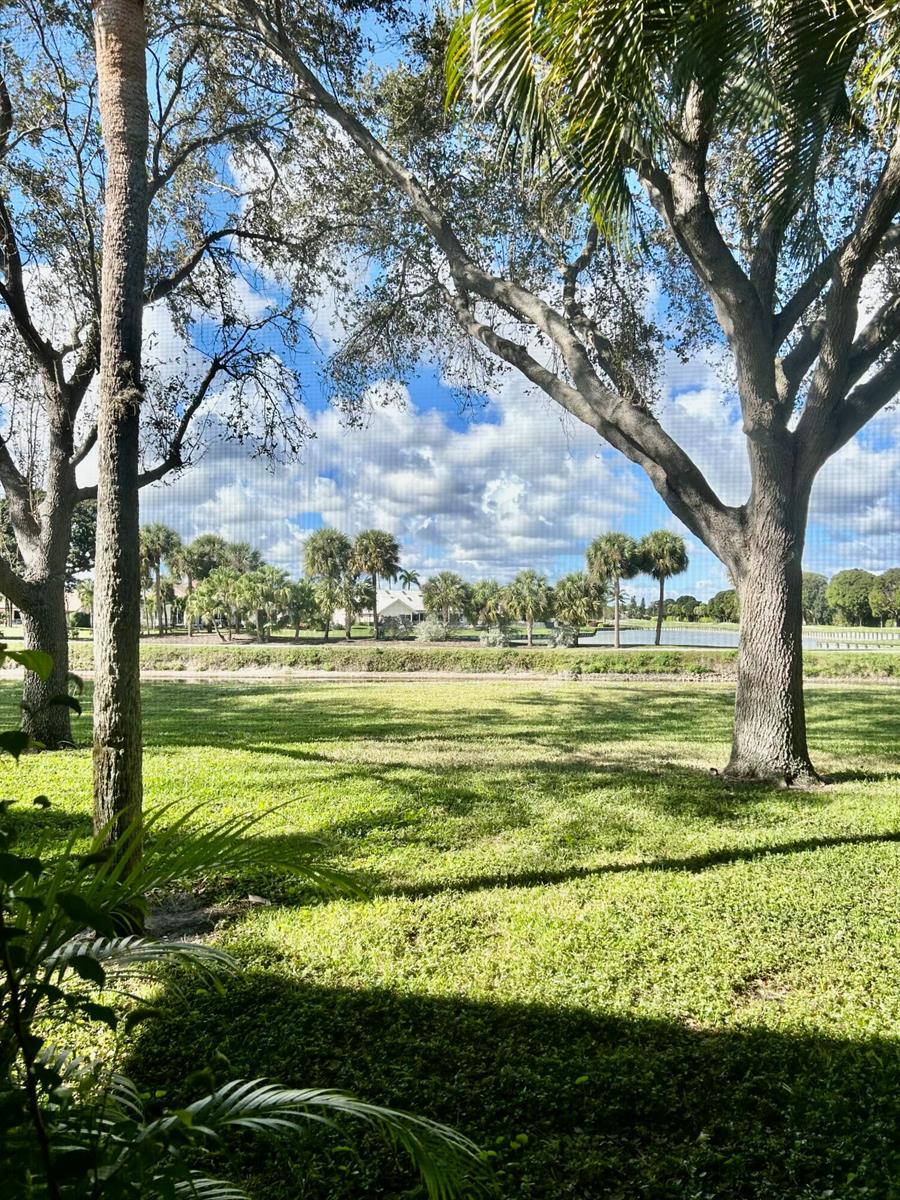 A kitchen features wood-grain cabinets, white appliances, and light-colored wood-look flooring — 2900 SW 22nd Circle # 221d, Delray Beach FL 33445, DELRAY BEACH, FL
