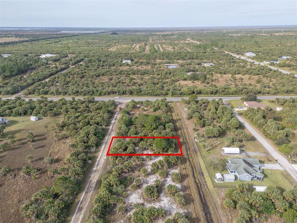 An aerial view shows a rectangular plot of land outlined in red amidst scrubby vegetation — 757 SANDLEWOOD STREET SW, PALM BAY, FL
