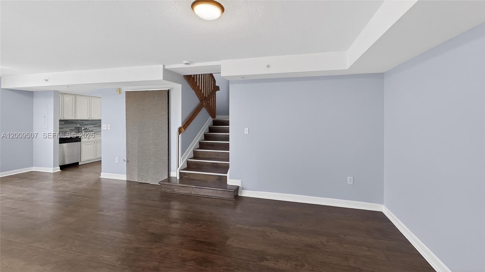 A room with dark wood flooring, light blue walls, and a staircase leading upward — 280 SW 20th Rd # 904, Miami FL 33129, MIAMI, FL