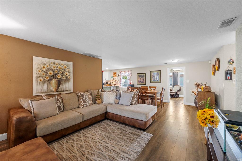 A living room features a large sectional sofa, a patterned rug, and a dining area — 2152 ARCADIA ROAD, HOLIDAY, FL