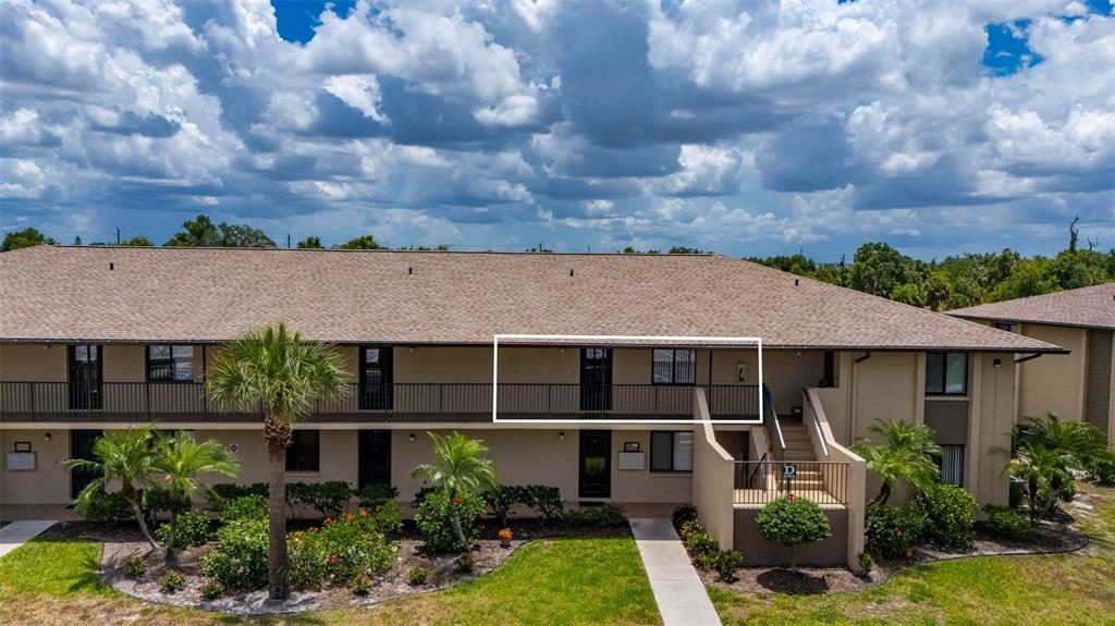 A two-story apartment building exterior features a second-floor balcony with a white rectangular outline — 4064 OAKVIEW DRIVE UNIT D9, PORT CHARLOTTE, FL