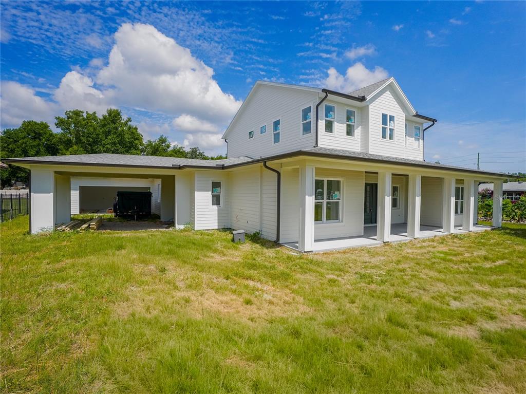 A two-story white house with a covered porch and an attached carport under construction — 1122 DINGENS AVENUE, GOTHA, FL