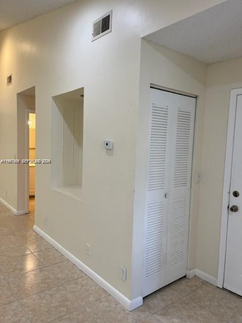 An interior view shows a tiled hallway with a recessed wall niche and louvered closet doors — 9999 Summerbreeze Dr # 918, Sunrise FL 33322, SUNRISE, FL