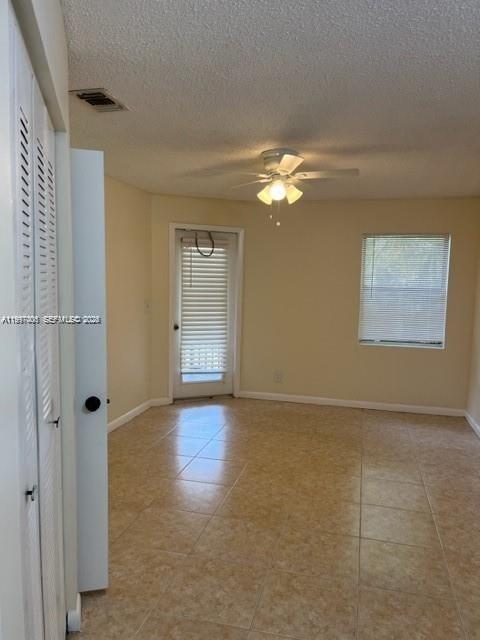 An empty room with beige tile flooring, a ceiling fan, and a glass-paned door — 9999 Summerbreeze Dr # 918, Sunrise FL 33322, SUNRISE, FL