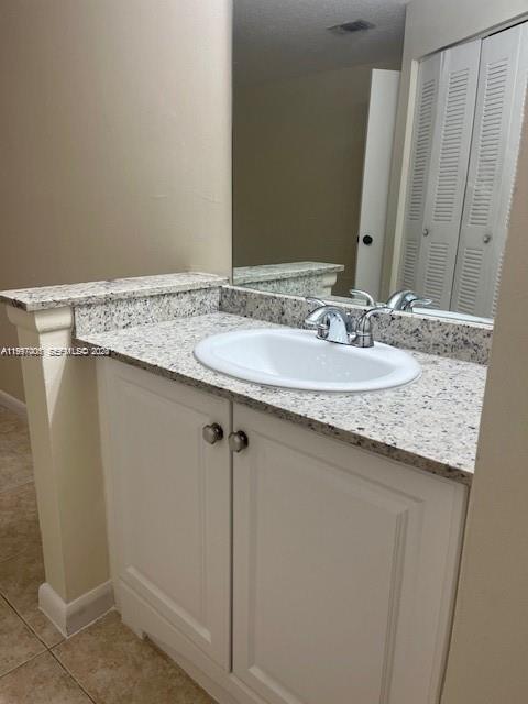 A bathroom vanity features a white cabinet, granite countertop, and a single sink — 9999 Summerbreeze Dr # 918, Sunrise FL 33322, SUNRISE, FL