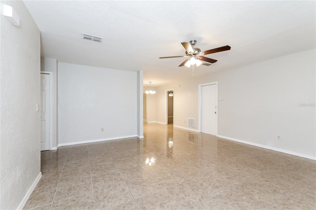 A spacious room with light-colored walls, tiled flooring, and a ceiling fan — 240 GRIFFORD DRIVE, KISSIMMEE, FL