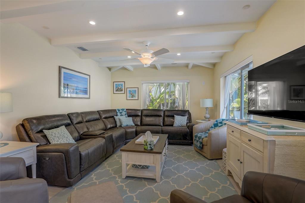 A living room features a large sectional sofa, a coffee table, and a television — 39 S POLK DRIVE, SARASOTA, FL